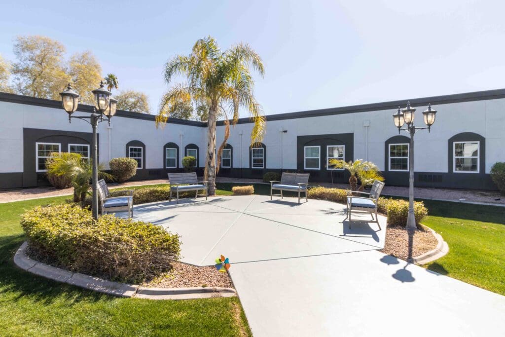 An exterior shot of Inspirations of Tempe's center courtyard with comfortable patio furniture in warm sunshine.