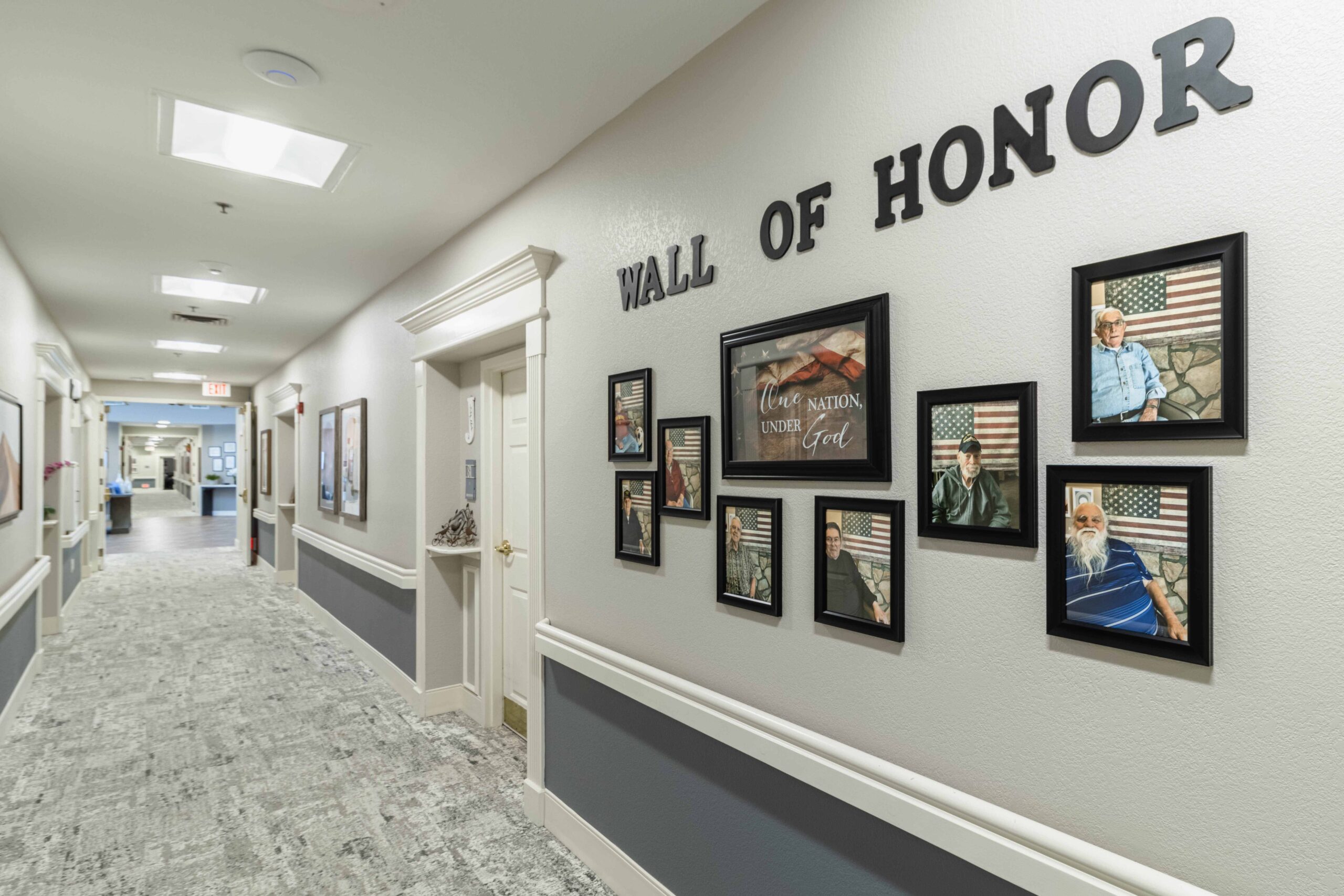 Interior photograph of the Inspirations of Tempe hallway decoration. The "Wall of Honor" holds photographs of veterans in the facility.